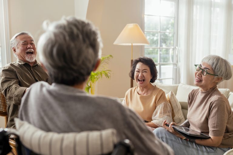 A group of senior citizens laughing together at their home