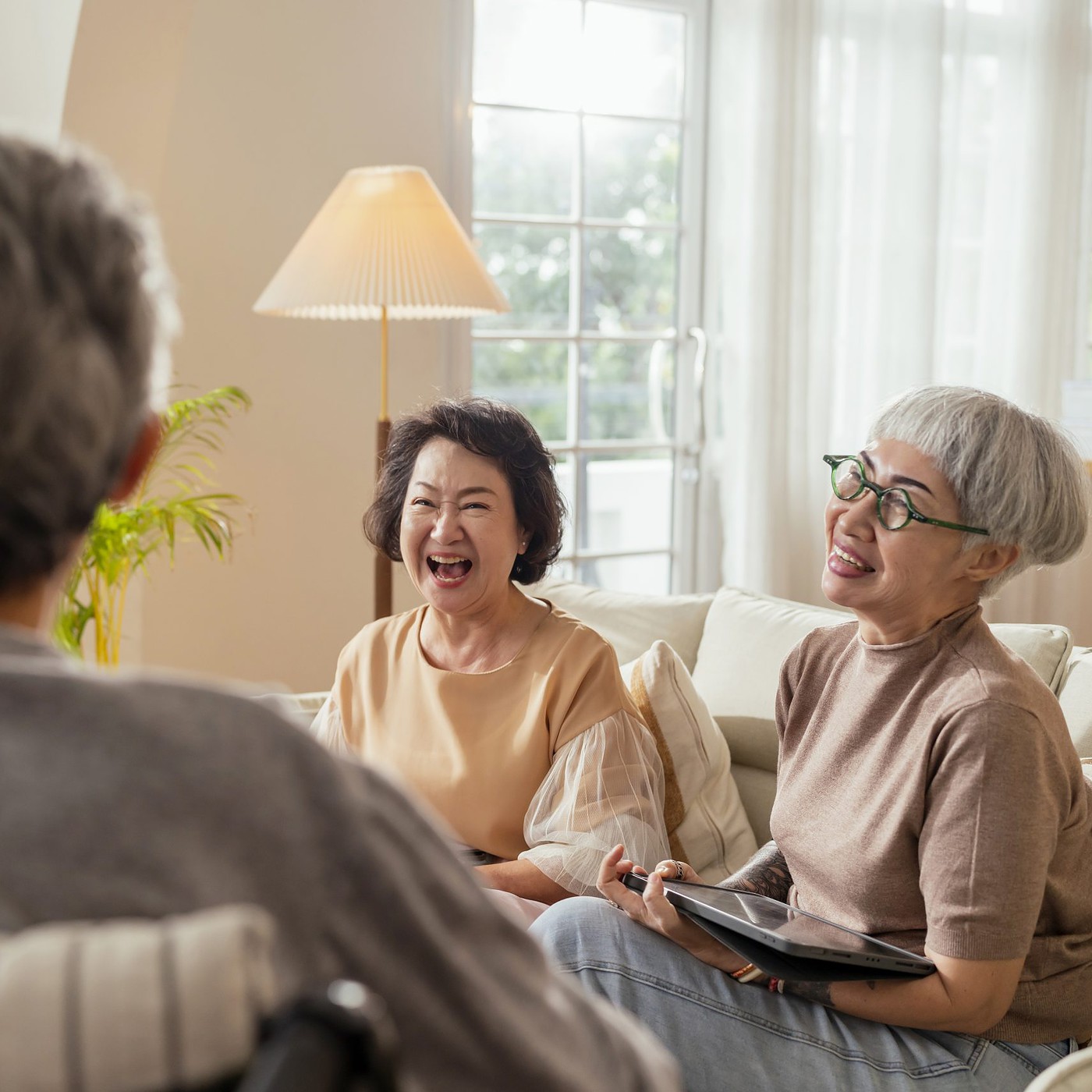 A group of senior citizens laughing together at their home